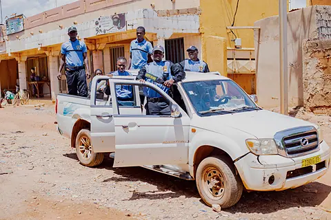 Pick-up de service et son équipe devant un bâtiment, à Ouagadougou.