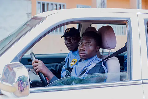 Agent au volant du véhicule d'intervention, radio à la ceinture.